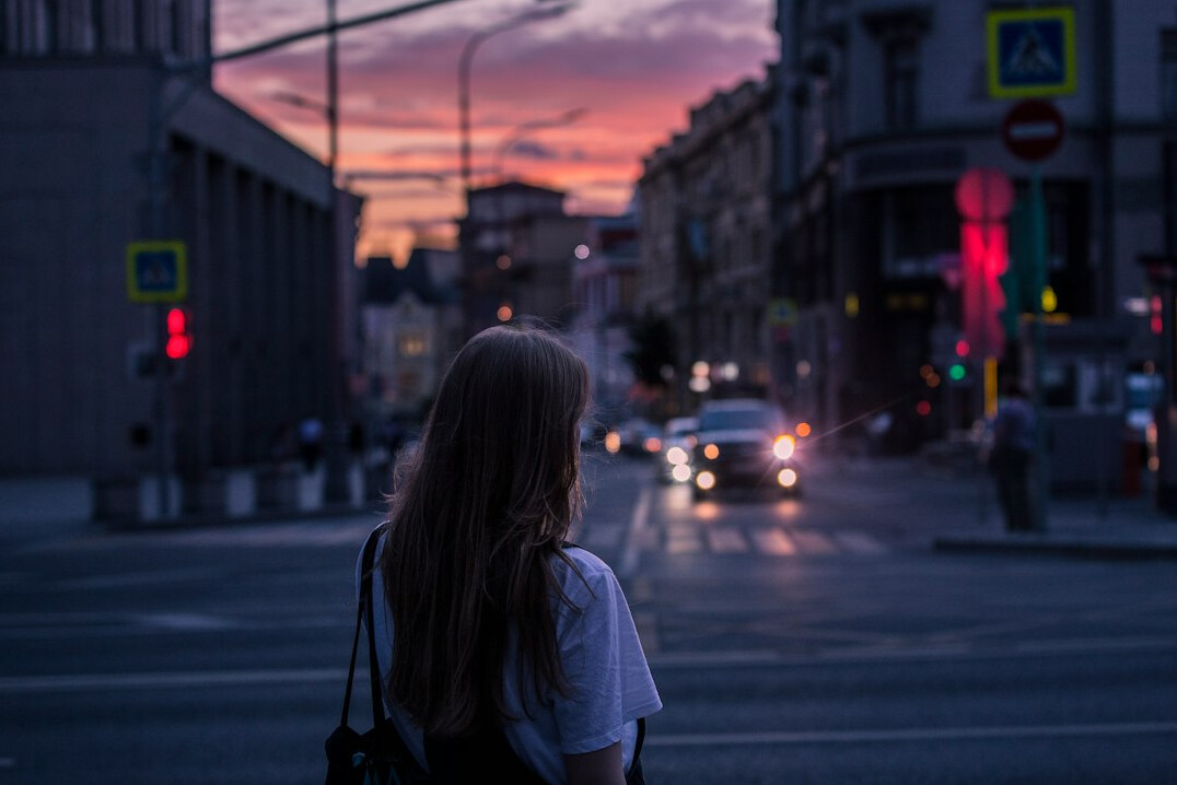 Fotograf idący ulicą małego miasta z aparatem